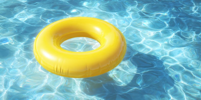 The vibrant yellow float relaxing in a crystal-clear pool water. photo