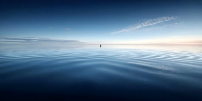 Small sailboat sailing on calm blue ocean water under a clear sky photo