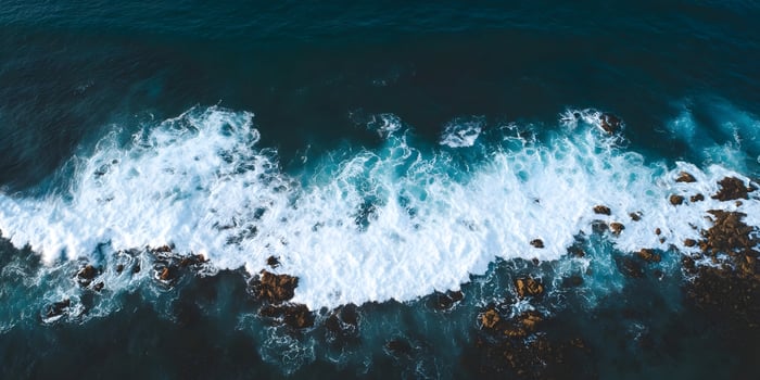 waves breaking rocks ocean photo