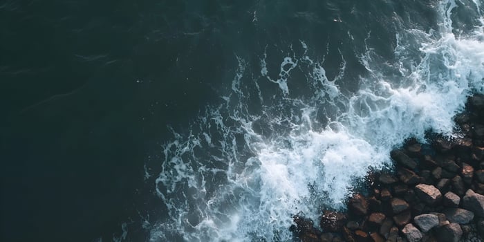 an aerial view of a rocky shore with waves photo