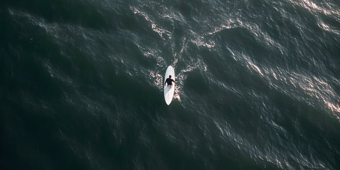 Man paddle boarding on dark ocean water photo