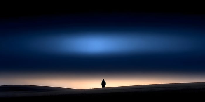 Silhouette of a person standing in a field at sunrise photo