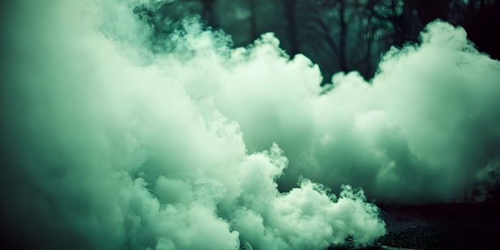 Green smoke clouds billowing outdoors near trees photo