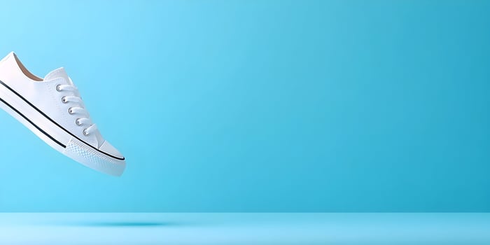 White canvas shoe floating against a light blue background photo