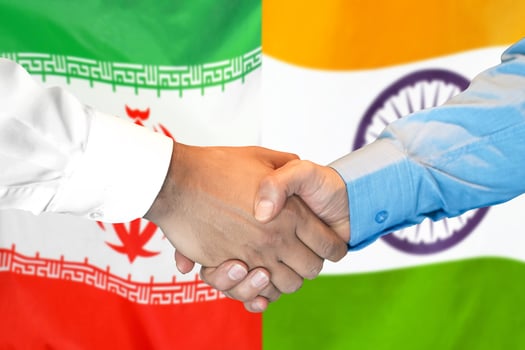 Handshake on Iran and India flag background. photo