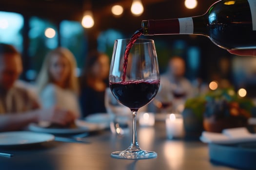 Pouring Red Wine at a Dinner Party photo