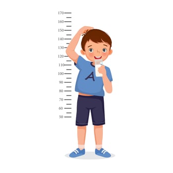 Cute Little boy drink a glass of milk and measuring height of her growth on the background of wall vector