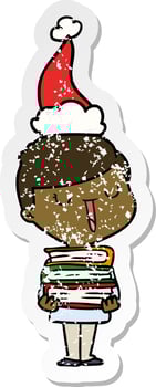 distressed sticker cartoon of a happy boy with stack of books wearing santa hat vector
