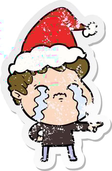 distressed sticker cartoon of a man crying wearing santa hat vector