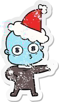distressed sticker cartoon of a weird bald spaceman wearing santa hat vector