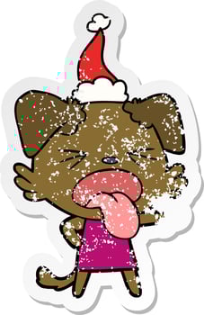 distressed sticker cartoon of a disgusted dog wearing santa hat vector