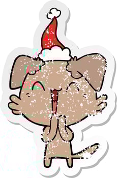 laughing little dog distressed sticker cartoon of a wearing santa hat vector