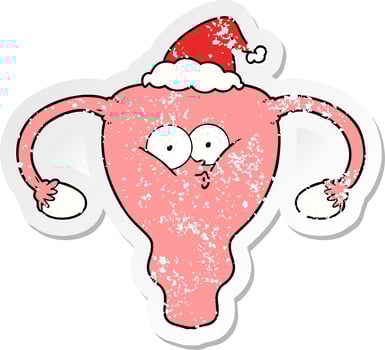distressed sticker cartoon of a uterus wearing santa hat vector
