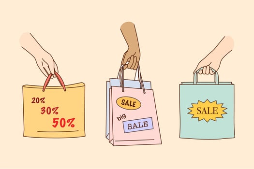 Big sale, shopping, discount in shops concept. People hands holding colorful shopping or gift bags with sale percents and discounts signs and symbols over yellow background illustration vector
