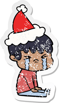 hand drawn distressed sticker cartoon of a boy crying wearing santa hat png