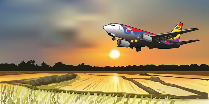 airline flying over rice field vector landscape with sunset in the background.