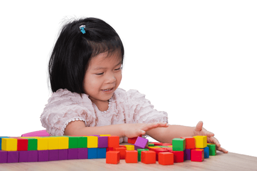 Cute Kid Girl is Playing with Colorful Wooden Blocks Placed on the Table, Children have Fun with Imagination, Construction, Creativity. Hours of rest, learning through play. Isolated background. png