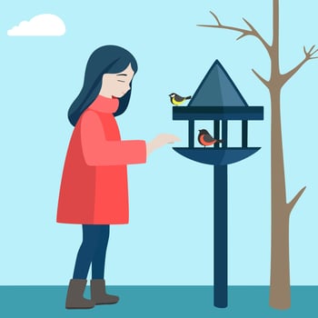The girl stands at the feeder in the cold season and feeds the birds vector