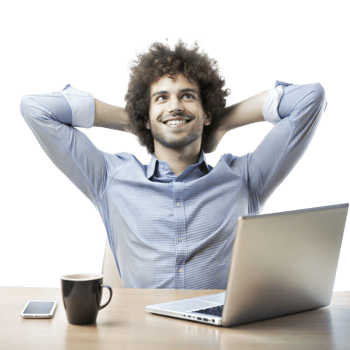 A cheerful man sits back with hands behind his head, smiling next to a laptop and coffee cup on a wooden desk png