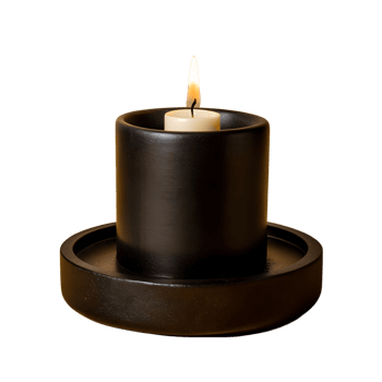 Minimalistic black candle burning on round tray. Elegant and soothing ambiance for relaxation and meditation. png
