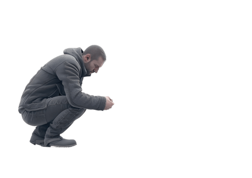 A man is squatting down, looking at something. Isolated on transparent background png
