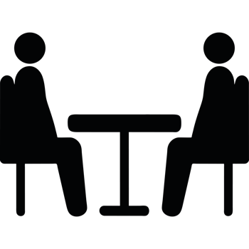 Two people sitting at a table in a dark room png