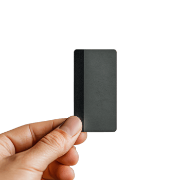 Hand holding a small black rectangular object on transparent background png