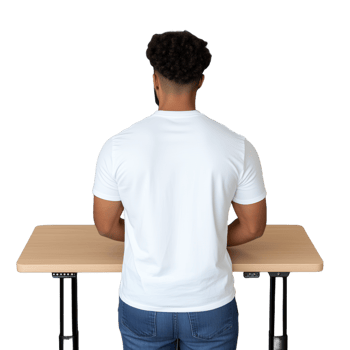 Rear view of a man with dark curly hair standing at an adjustable height table, wearing a white t-shirt and blue jeans, on a transparent background png