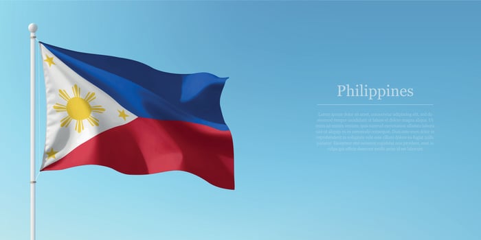 Waving Flag of Philippines Against Clear Blue Sky Copyspace vector