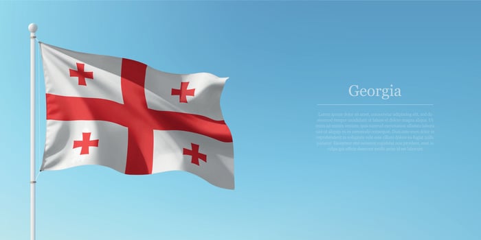 Waving Flag of Georgia Against Clear Blue Sky Copyspace vector