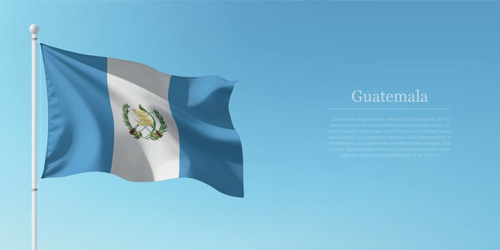 Waving Flag of Guatemala Against Clear Blue Sky Copyspace vector