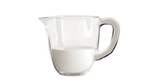 Clear glass measuring cup filled with fresh milk on a transparent background placed in a kitchen setting. png