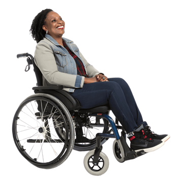 Woman sitting in a wheelchair smiling while wearing casual clothing in an indoor setting png