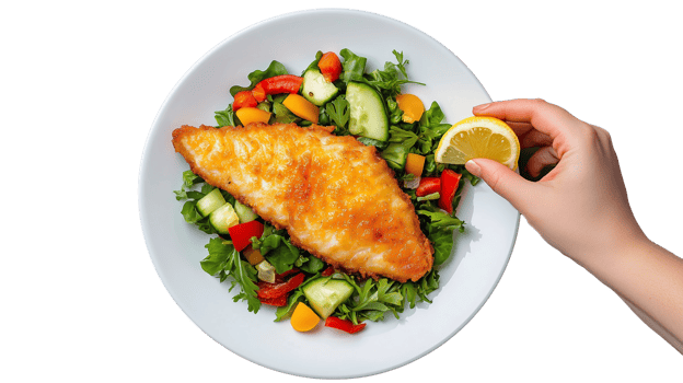 Crispy fish fillet on vibrant salad with lemon slice, transparent background png