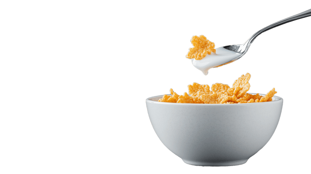 Crunchy cornflakes with milk on spoon and bowl, transparent background png