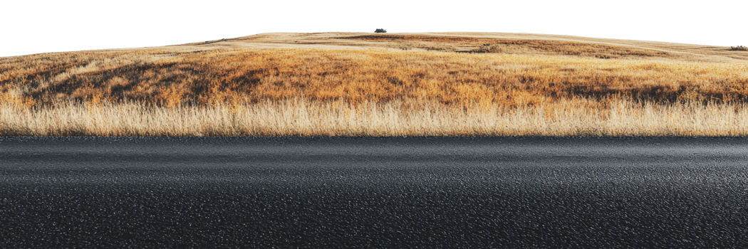 Wide open landscape with grass and road at sunset png