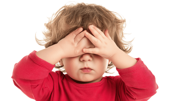 A toddler playfully covering their eyes during a fun game of peek-a-boo, showcasing innocent joy and engagement in early childhood playtime activities. png