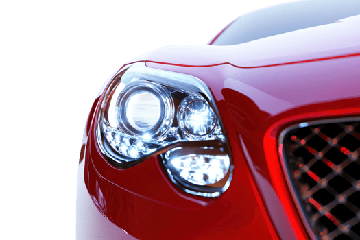 A close-up of a sleek red car's headlight, showcasing its modern design and glossy finish against a transparent background. png