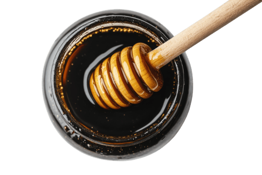 Honey in glass jar with wooden dipper glistening under bright light png