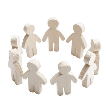 Wooden figures forming a circle to symbolize unity and community in teamwork. png