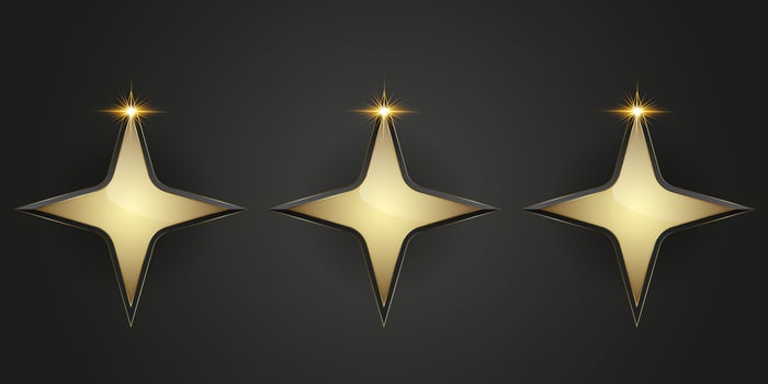 Three golden stars with smooth, reflective surfaces, radiating luxury and elegance. vector