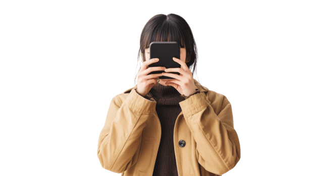 Young woman holding a smartphone while dressed in a casual beige jacket and a warm sweater, indoors, engaged in capturing moments png