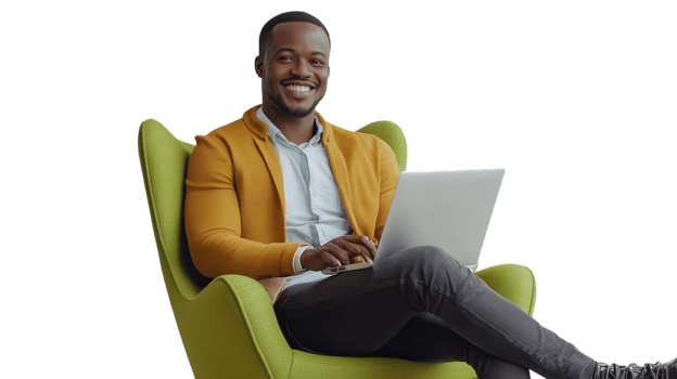 Smiling man sitting comfortably in a green armchair while using a laptop indoors png