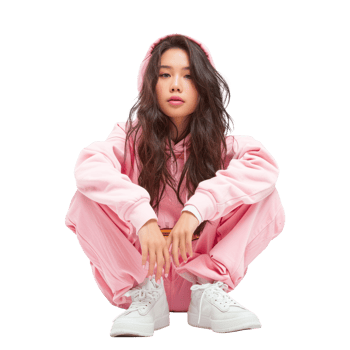 A girl in pink sweats and sneakers sitting on the floor png