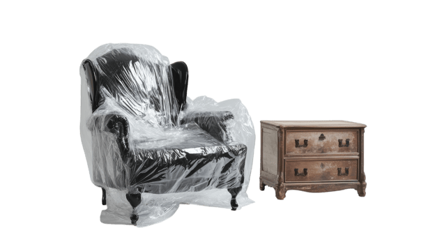 Black upholstered armchair wrapped in plastic with a wooden bedside table placed beside it png
