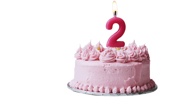 Two-year-old birthday cake with pink frosting and candle on top celebrating a special occasion filled with joy and sweetness png