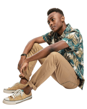 Young man in floral shirt poses thoughtfully in casual outfit at studio png