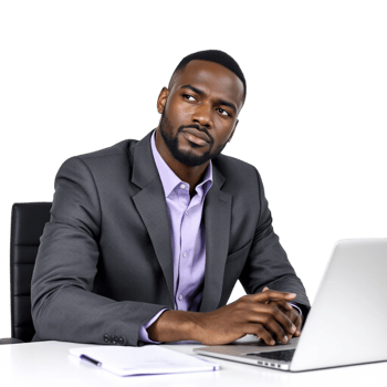 A black man in a suit sitting at a desk with a laptop png