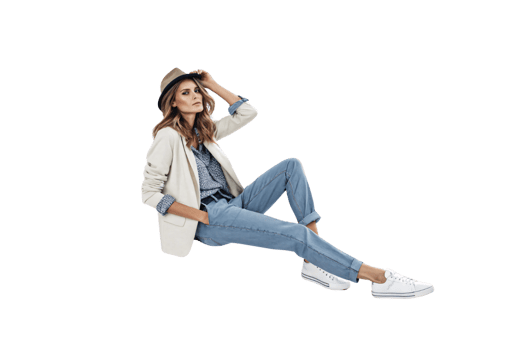 A stylish woman sits relaxed, wearing a beige blazer, jeans, a hat, and sneakers. Her confident pose reflects effortless casual chic png