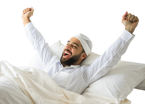 Smiling Muslim man in traditional attire waking up, arms raised in a relaxed morning stretch, bright and cheerful setting png